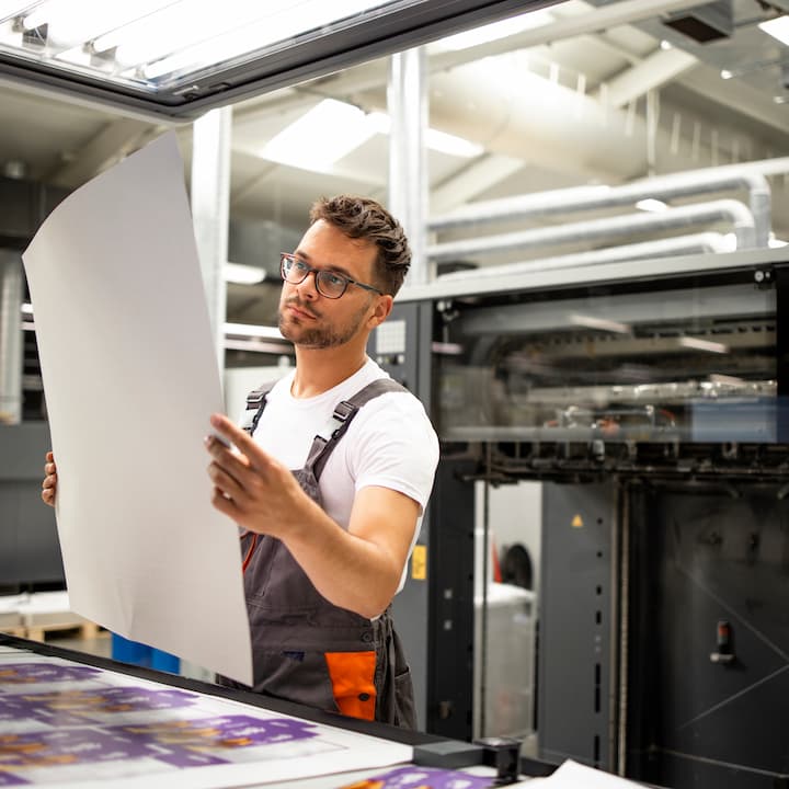 A print professional examining a poster | Talk to the experts about what printers are right for your office